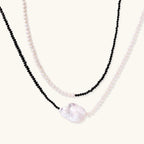 Double-strand necklace with black faceted quartz and white pearls featuring an oversized baroque pearl centerpiece